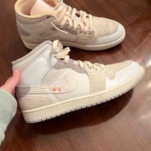 Air Jordan 1 Mid SE 'Inside out'. Colors are white, cream, gray, and orange.